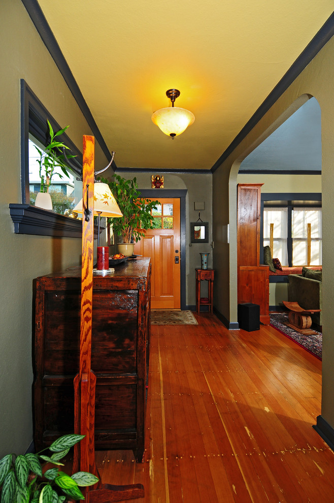 Esempio di un piccolo ingresso stile americano con pareti verdi, pavimento in legno massello medio, una porta singola e una porta in legno bruno