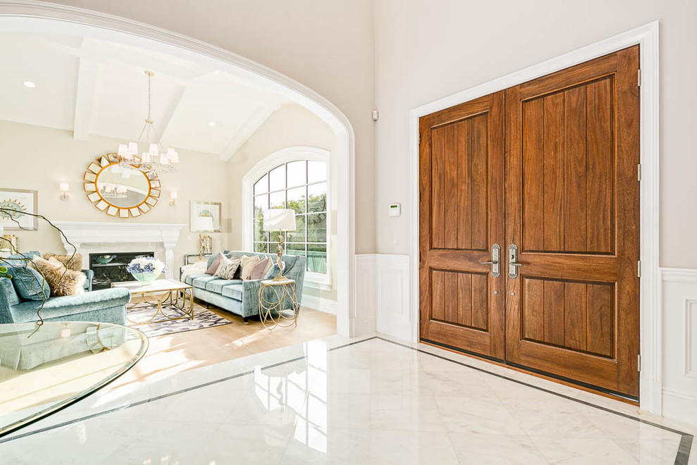 Entryway - large transitional marble floor and white floor entryway idea in Los Angeles with gray walls and a medium wood front door