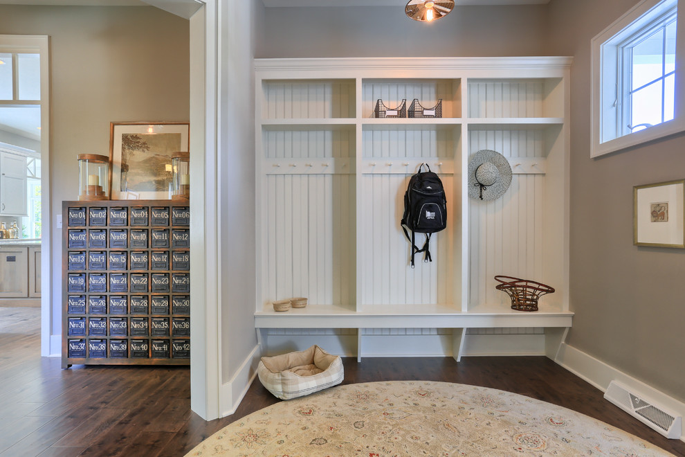 Large cottage dark wood floor mudroom photo in Other with beige walls