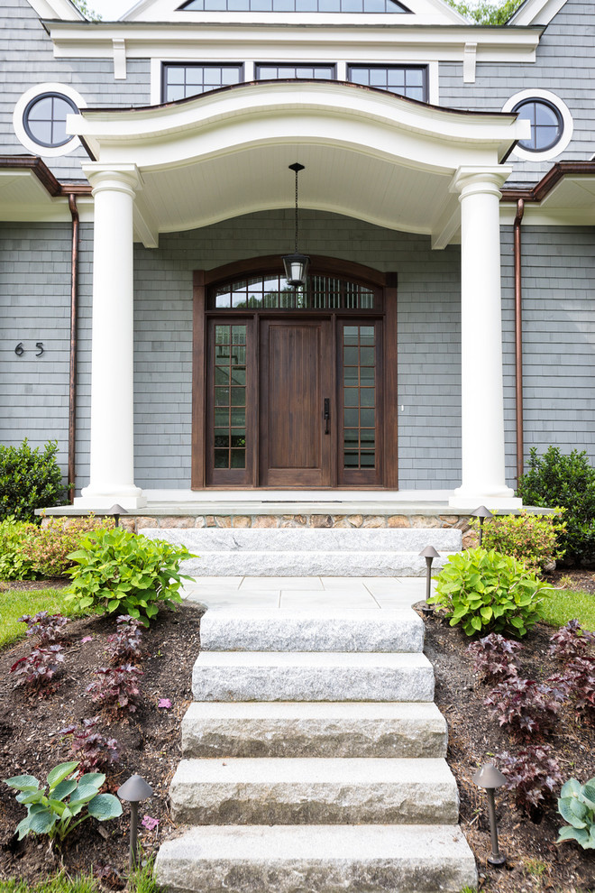 This is an example of an expansive traditional front door in Boston with a single front door and a dark wood front door.