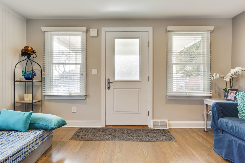 Ejemplo de puerta principal costera de tamaño medio con paredes marrones, suelo de madera clara, puerta simple y suelo marrón