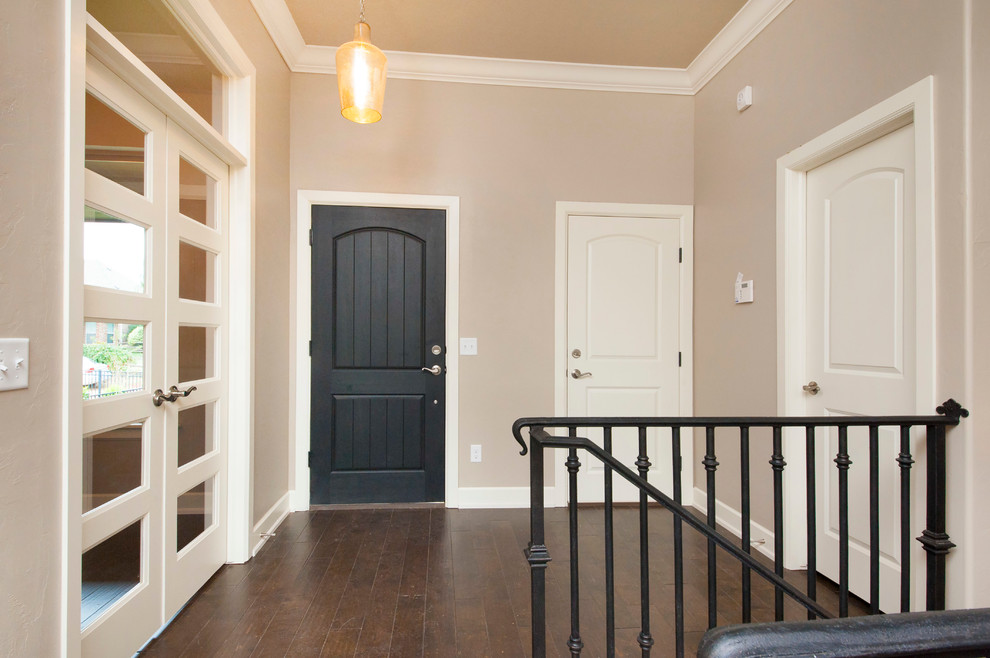 Idée de décoration pour une porte d'entrée tradition de taille moyenne avec un mur beige, parquet foncé, une porte double, une porte en verre et un sol marron.