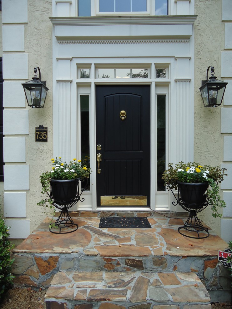 他の地域にあるトラディショナルスタイルのおしゃれな玄関ドア (黒いドア) の写真
