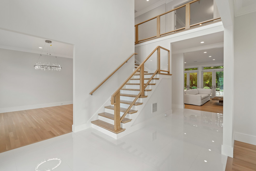 This is an example of a large modern foyer in Boston with white walls, porcelain flooring, a double front door, a dark wood front door and white floors.