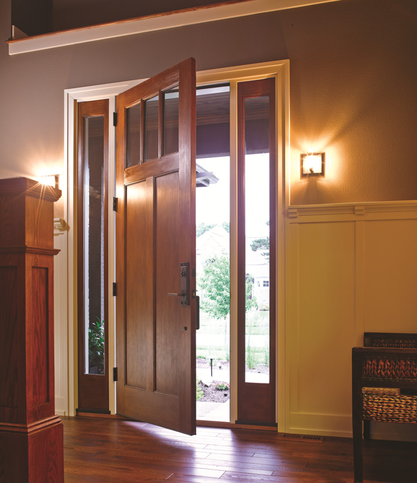 Ejemplo de entrada de estilo americano con puerta simple, paredes grises, suelo de madera en tonos medios y puerta de madera en tonos medios