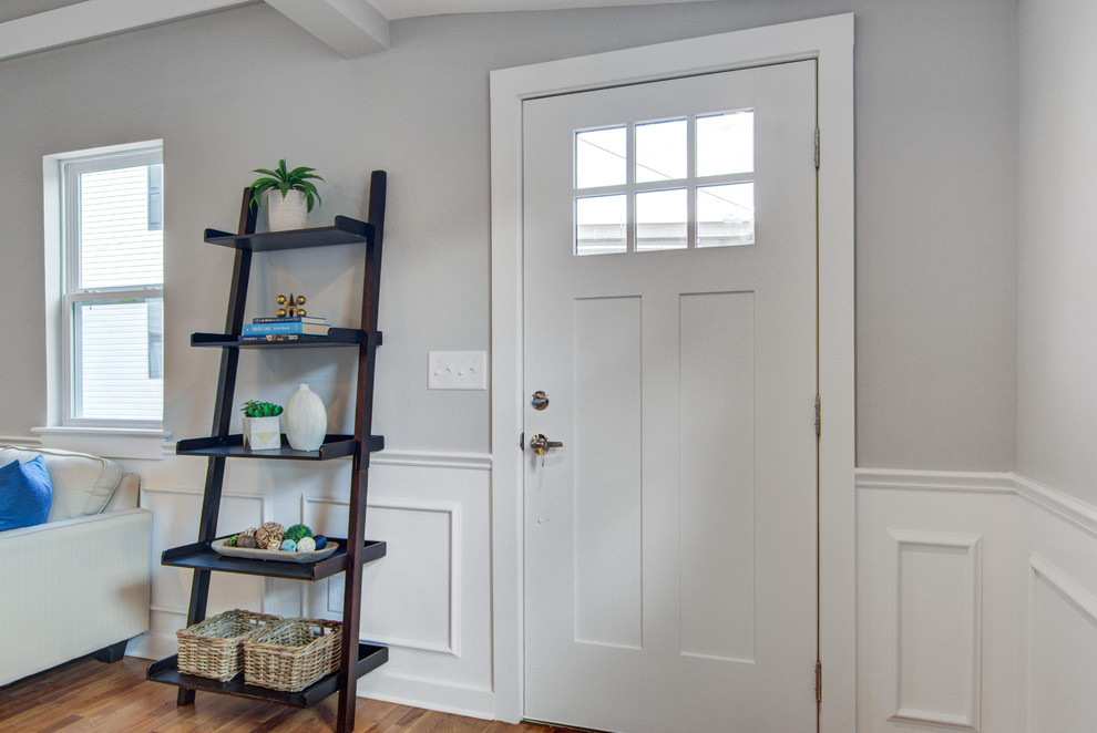 Источник вдохновения для домашнего уюта: фойе в стиле неоклассика (современная классика) с серыми стенами, паркетным полом среднего тона, одностворчатой входной дверью и коричневым полом