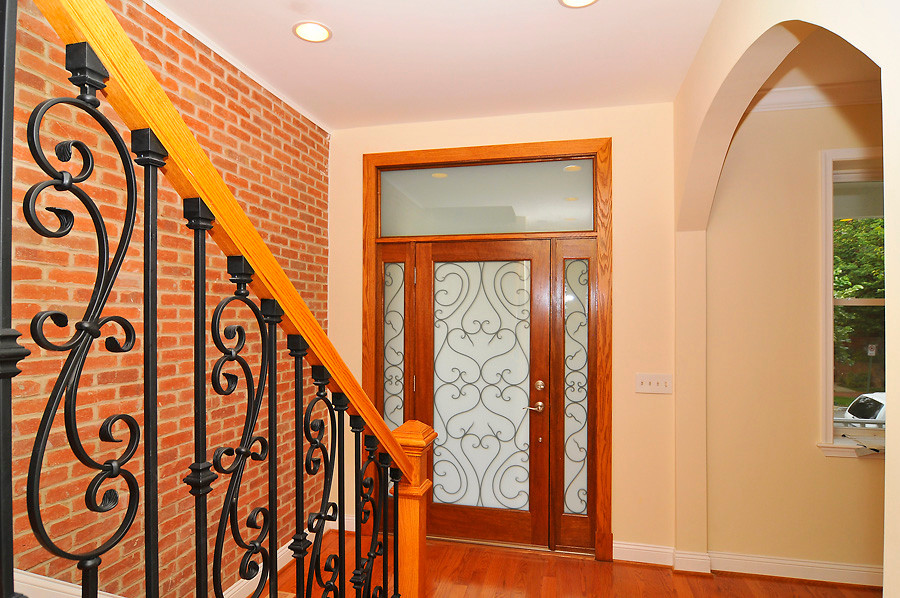 На фото: входная дверь среднего размера в классическом стиле с паркетным полом среднего тона, одностворчатой входной дверью, разноцветными стенами и стеклянной входной дверью с