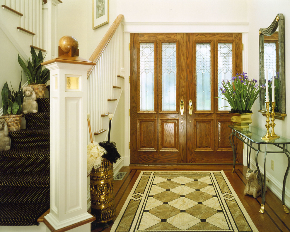 Inspiration pour une porte d'entrée traditionnelle de taille moyenne avec un mur blanc, un sol en bois brun, une porte double et une porte marron.