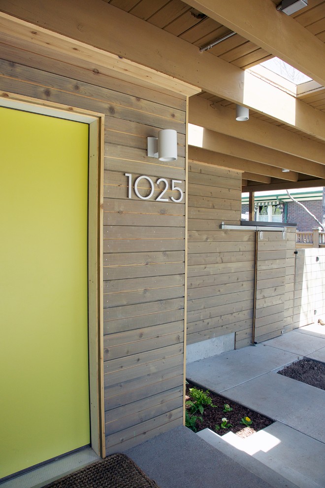 Foto di una piccola porta d'ingresso moderna con pareti marroni, pavimento in legno massello medio, una porta singola e una porta verde