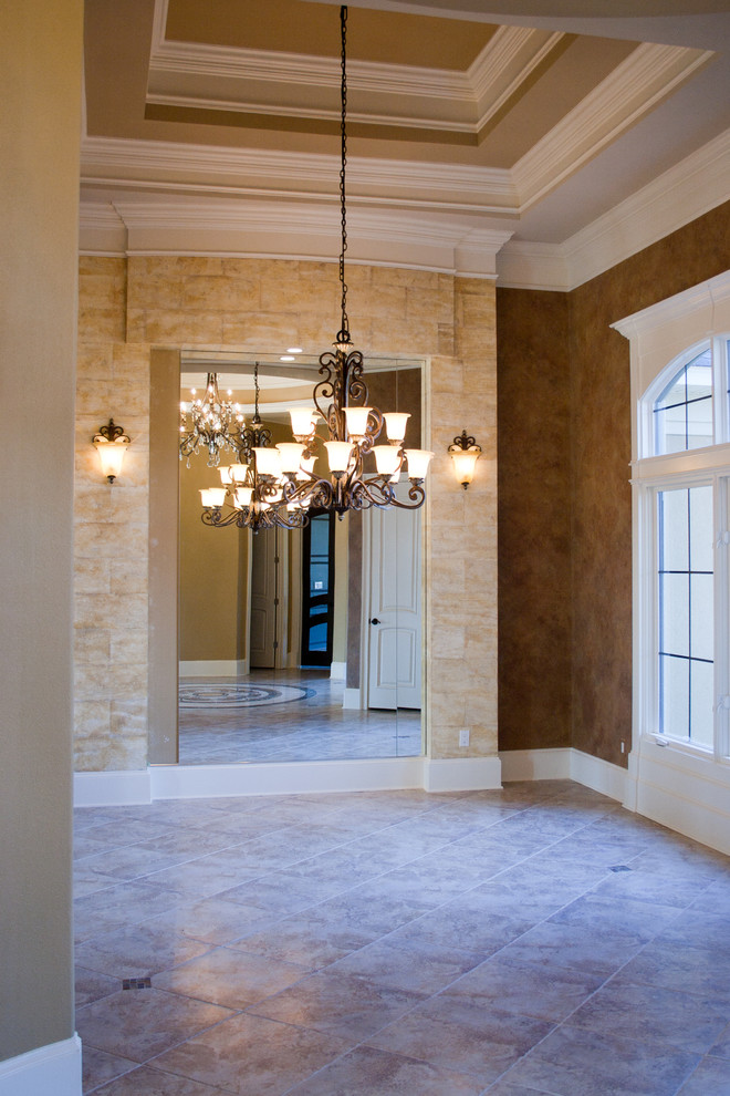 Foto di un ampio corridoio classico con pareti marroni, pavimento in marmo, una porta singola e una porta bianca