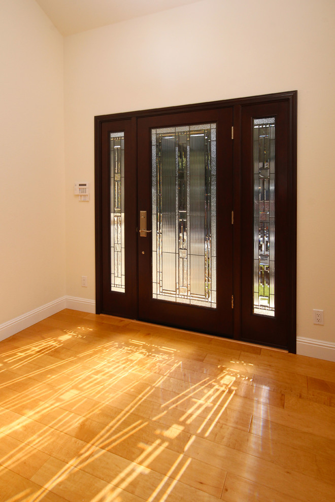 Ispirazione per un grande ingresso moderno con pareti gialle, pavimento in legno massello medio, una porta singola e una porta in legno scuro