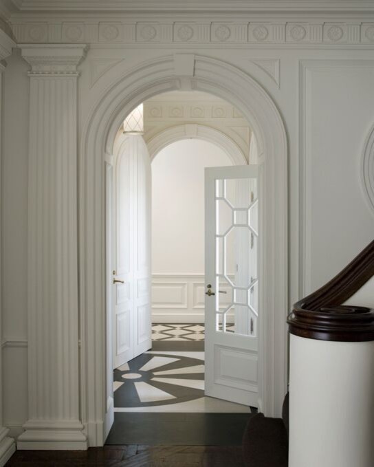 Идея дизайна: большое фойе в классическом стиле с белыми стенами, полом из керамической плитки, поворотной входной дверью, белой входной дверью и черным полом