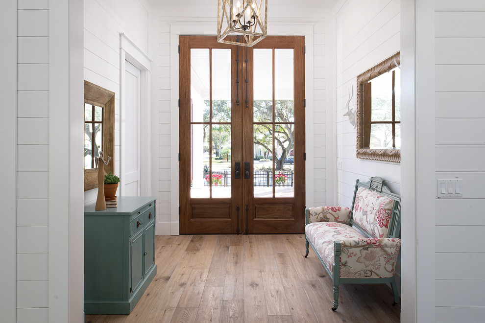 Imagen de hall tradicional renovado pequeño con paredes blancas, puerta doble, puerta de madera en tonos medios y suelo de madera en tonos medios