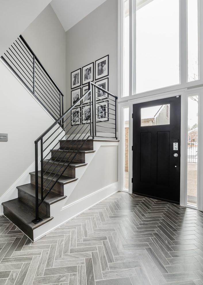 Idee per un ingresso design di medie dimensioni con pareti grigie, pavimento in gres porcellanato, una porta singola, una porta nera e pavimento grigio