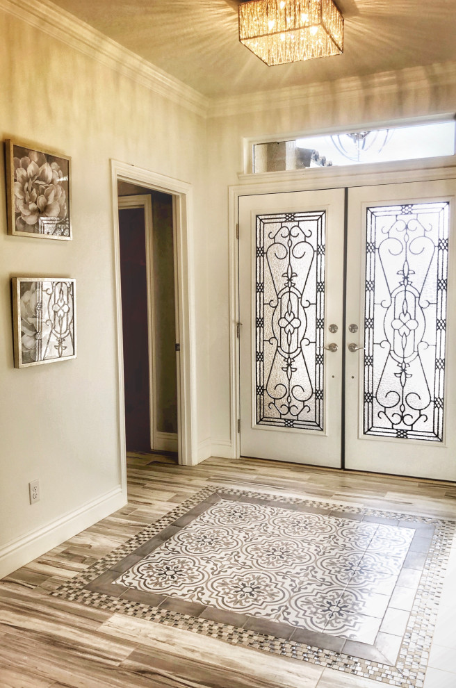 Idee per un ingresso bohémian di medie dimensioni con pareti bianche, pavimento in gres porcellanato, una porta a due ante, una porta bianca e pavimento multicolore