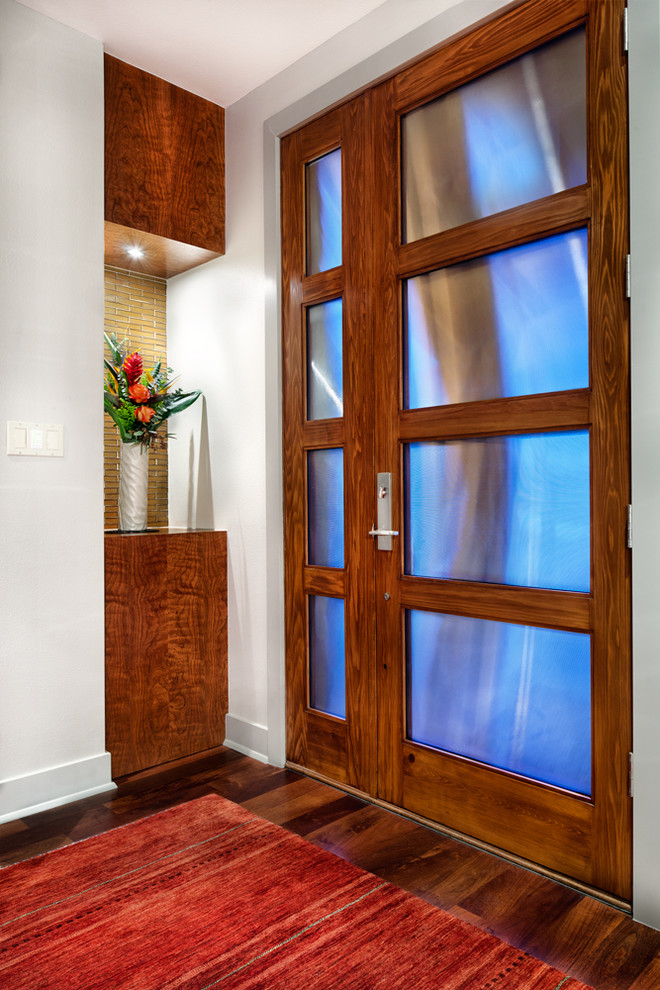 Cette photo montre une entrée tendance avec un mur blanc, un sol en bois brun et une porte simple.