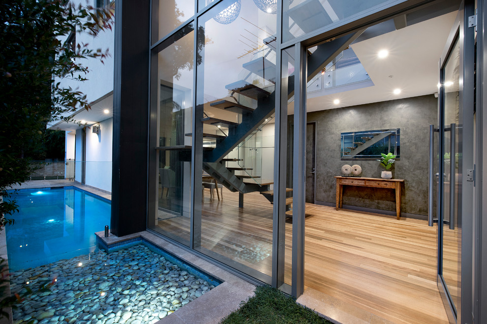 Große Moderne Haustür mit grauer Wandfarbe, hellem Holzboden, Drehtür und Haustür aus Glas in Sydney