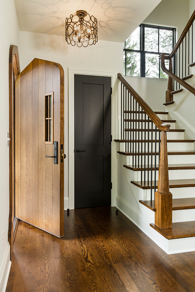 Пример оригинального дизайна: фойе среднего размера в стиле неоклассика (современная классика) с белыми стенами, темным паркетным полом, одностворчатой входной дверью, входной дверью из темного дерева и коричневым полом