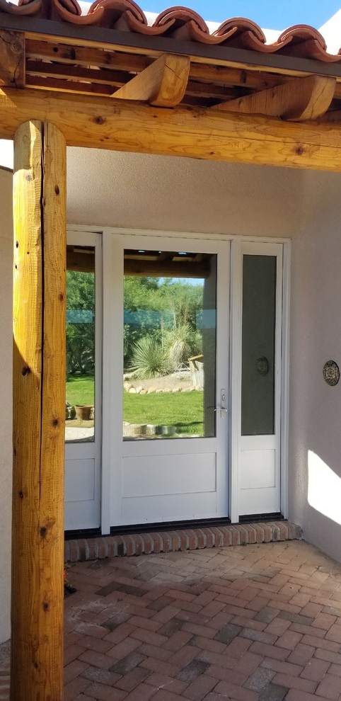 Medium sized front door in Phoenix with white walls, brick flooring, a single front door, a white front door and red floors.