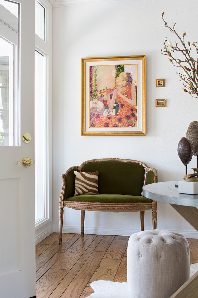 Example of a mid-sized trendy light wood floor and brown floor entryway design in Los Angeles with white walls and a black front door