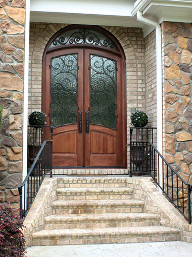 Immagine di una grande porta d'ingresso tropicale con una porta a due ante e una porta in vetro