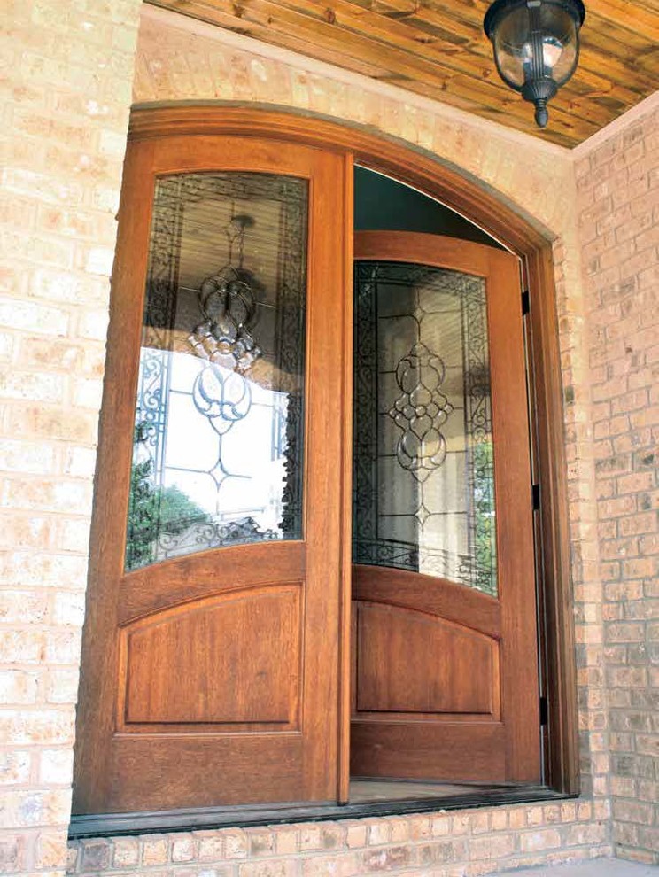 Ejemplo de puerta principal mediterránea de tamaño medio con paredes rosas, suelo de ladrillo, puerta doble y puerta de madera clara