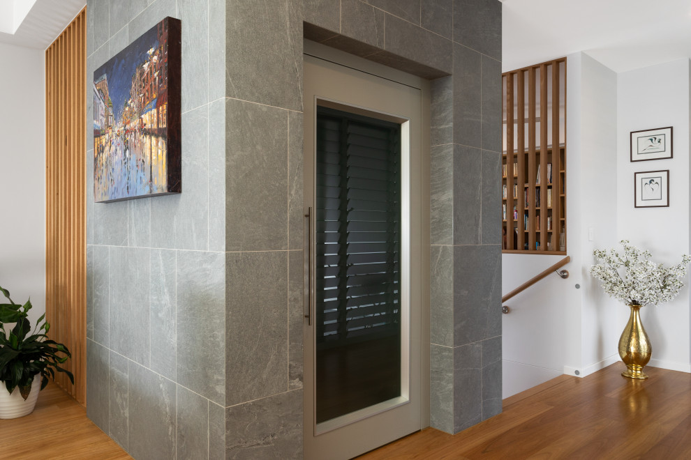 This is an example of a medium sized beach style foyer in Brisbane with white walls, medium hardwood flooring, a pivot front door, a brown front door and brown floors.