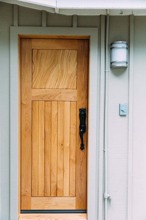 Ejemplo de puerta principal bohemia de tamaño medio con paredes beige, suelo de madera clara, puerta simple y puerta de madera clara