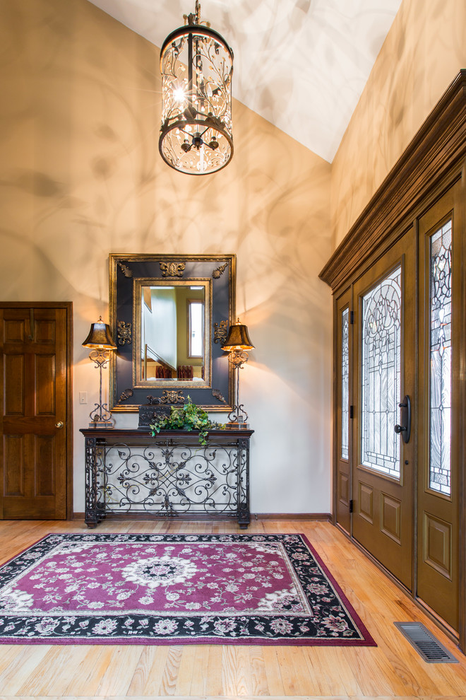 Foto de distribuidor clásico con paredes beige, suelo de madera en tonos medios, puerta simple y puerta de vidrio