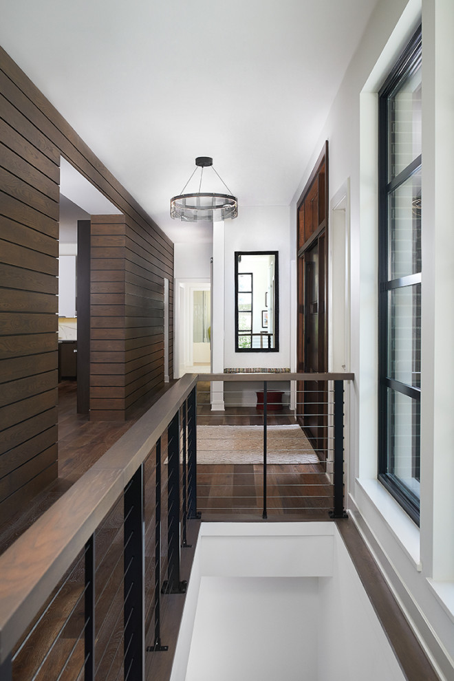 Idee per un corridoio minimalista con pareti bianche, parquet scuro, una porta a pivot, una porta in legno scuro e pavimento marrone