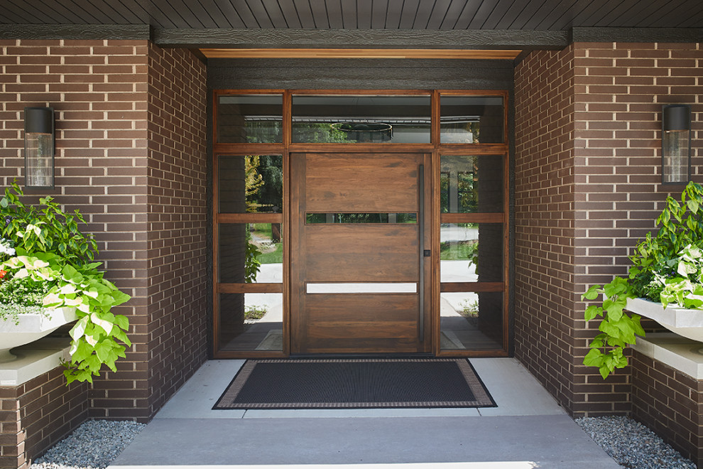 Example of a 1950s pivot front door design in Grand Rapids with a dark wood front door