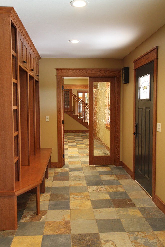 Exemple d'une entrée craftsman avec un vestiaire, un sol en ardoise et une porte noire.