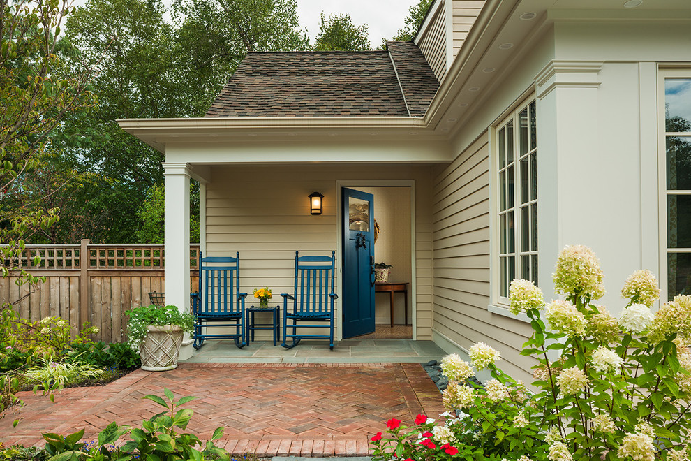 На фото: маленькое фойе в стиле неоклассика (современная классика) с бежевыми стенами, кирпичным полом, одностворчатой входной дверью и синей входной дверью для на участке и в саду с