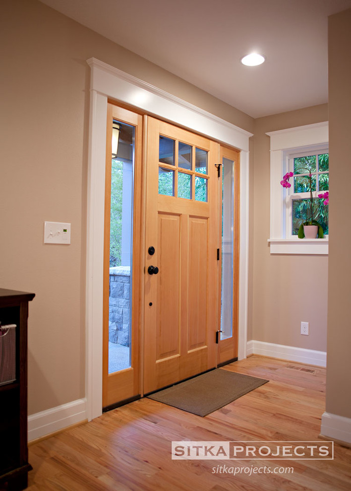 Idées déco pour un hall d'entrée classique de taille moyenne avec un mur beige, parquet clair, une porte simple et une porte en bois clair.