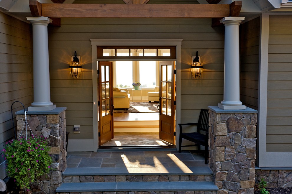 Cette image montre une entrée traditionnelle avec une porte double et une porte en bois foncé.