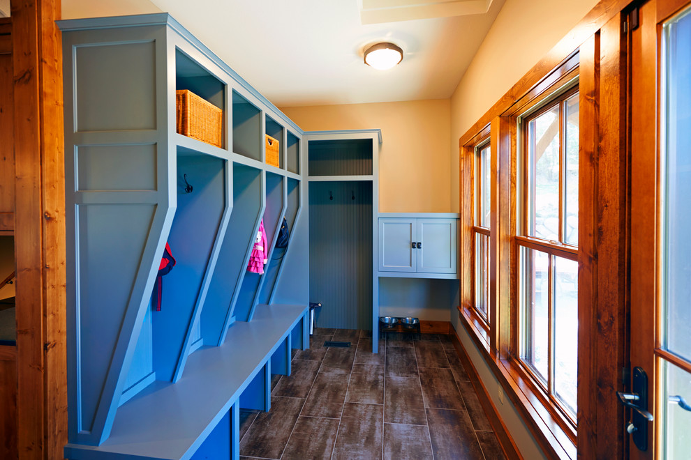 This is an example of a medium sized country boot room in Minneapolis with beige walls, ceramic flooring, a single front door and a medium wood front door.