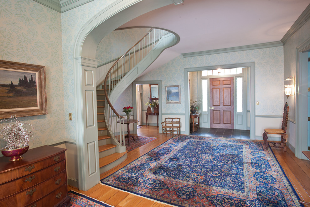 Klassisches Foyer mit braunem Holzboden, Einzeltür, hellbrauner Holzhaustür und grüner Wandfarbe in Sonstige