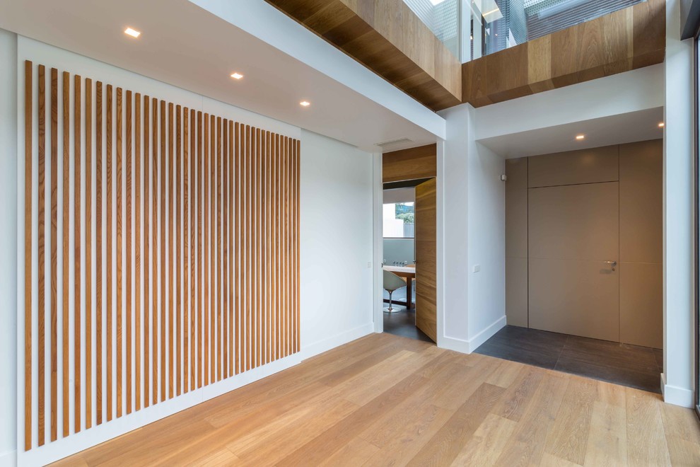 Idee per un ingresso minimal di medie dimensioni con pavimento in legno massello medio e una porta singola