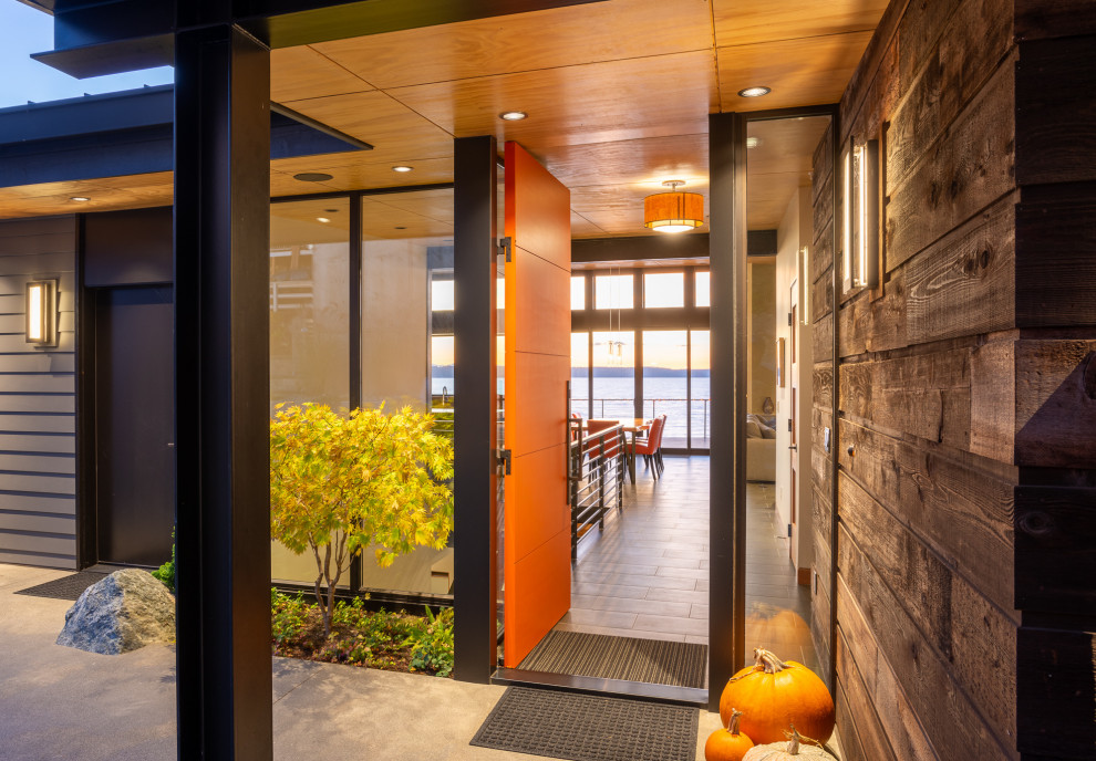 Foto di una porta d'ingresso moderna di medie dimensioni con pareti marroni, pavimento in gres porcellanato, una porta singola, una porta arancione e pavimento grigio