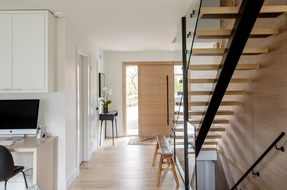 Inspiration pour une grande entrée design avec un couloir, un mur blanc, une porte simple, une porte en bois clair et un sol beige.