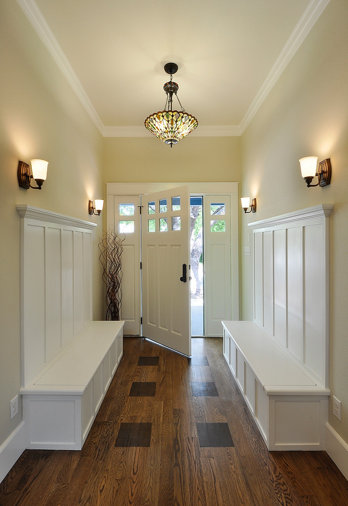 Idée de décoration pour une entrée tradition avec un mur beige, parquet foncé, une porte simple et une porte blanche.