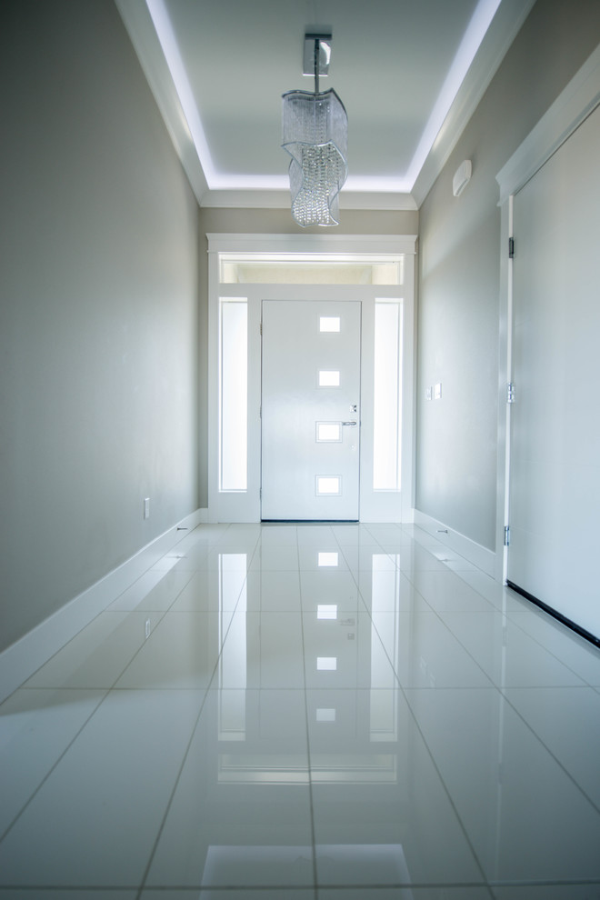 Foto di un piccolo ingresso minimalista con pareti grigie, pavimento in gres porcellanato, una porta singola, una porta bianca e pavimento bianco