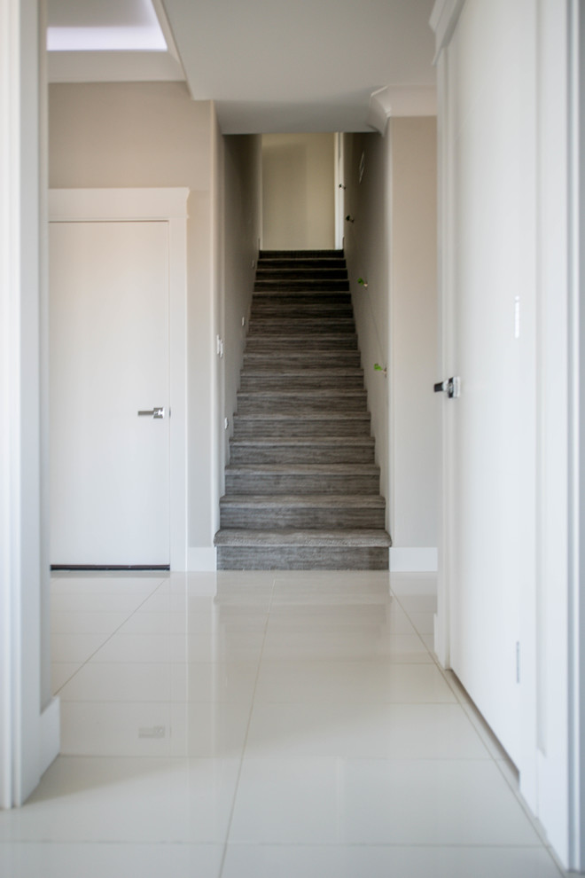 Ispirazione per un piccolo ingresso moderno con pareti grigie, pavimento in gres porcellanato, una porta singola, una porta bianca e pavimento bianco