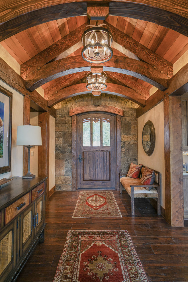 Mittelgroßes Uriges Foyer mit beiger Wandfarbe, dunklem Holzboden, Einzeltür, dunkler Holzhaustür und braunem Boden in Denver