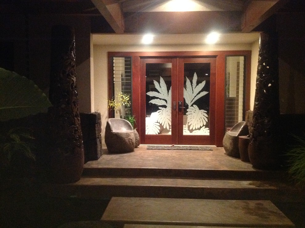 ハワイにある高級な広いトロピカルスタイルのおしゃれな玄関ドア (白い壁、濃色無垢フローリング、濃色木目調のドア) の写真