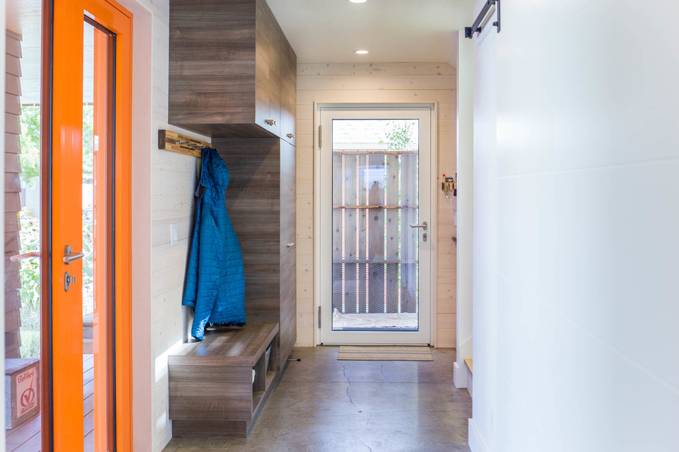 Kleine Moderne Haustür mit weißer Wandfarbe, Betonboden, Einzeltür, oranger Haustür und grauem Boden in Sonstige