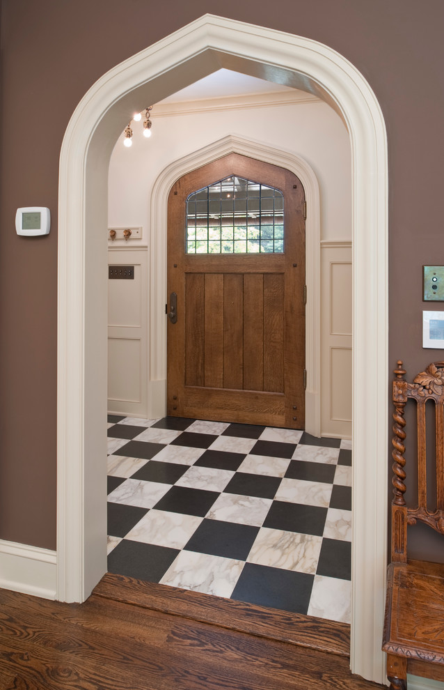 Inspiration pour une entrée traditionnelle avec un mur beige, parquet foncé, une porte simple, une porte en bois foncé et un sol multicolore.