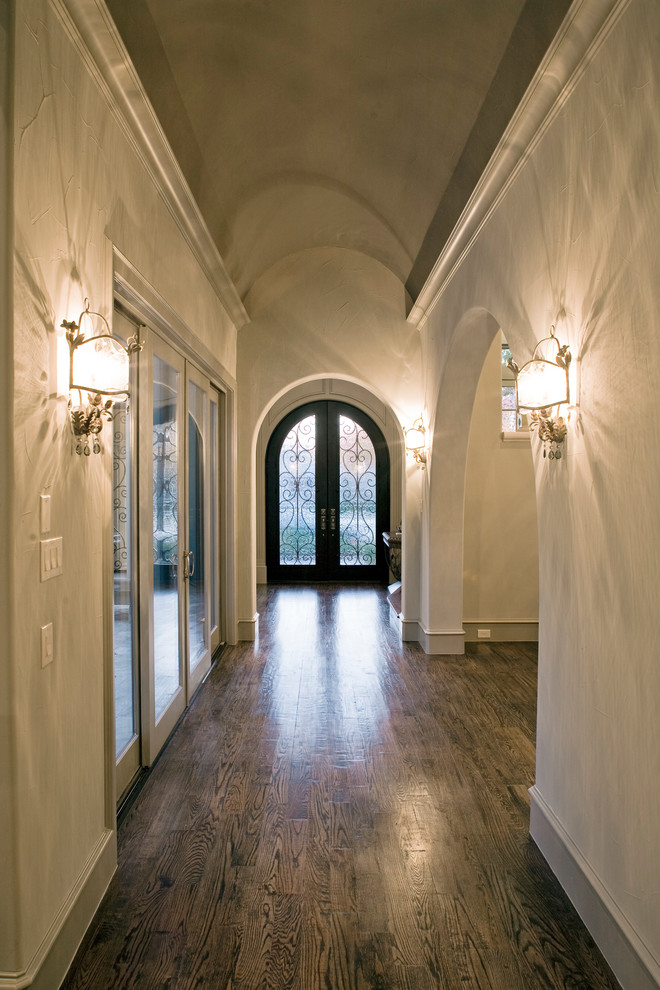 Ejemplo de hall mediterráneo de tamaño medio con paredes beige, suelo de madera oscura, puerta doble, puerta metalizada y suelo marrón