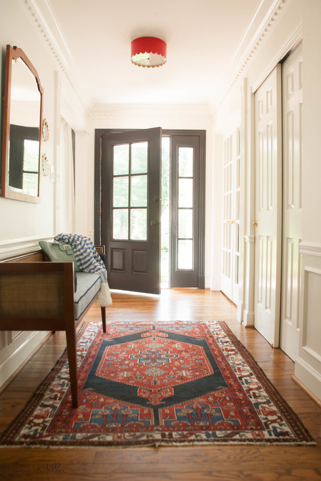 Kleines Klassisches Foyer mit weißer Wandfarbe, braunem Holzboden, Einzeltür und schwarzer Haustür in St. Louis