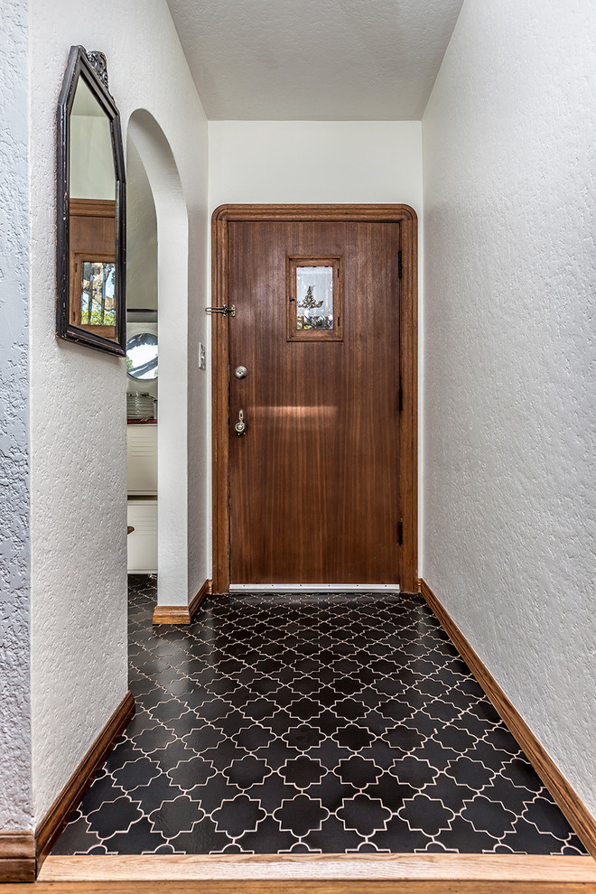 Kleine Haustür mit weißer Wandfarbe, Keramikboden, Einzeltür, brauner Haustür und schwarzem Boden in Los Angeles